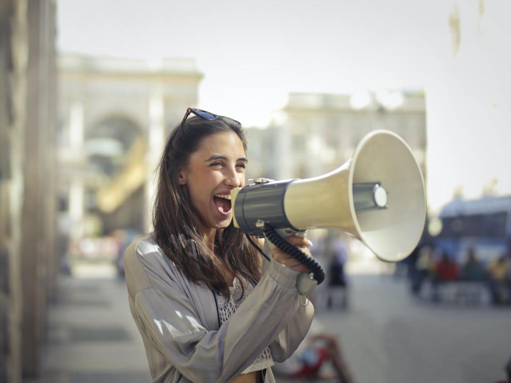 A woman holding a microphone. Photo by Andrea Piacquadio from Pexels